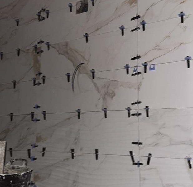 Alicatado de baño en porcelánico efecto mármol Calacatta con crucetas niveladoras