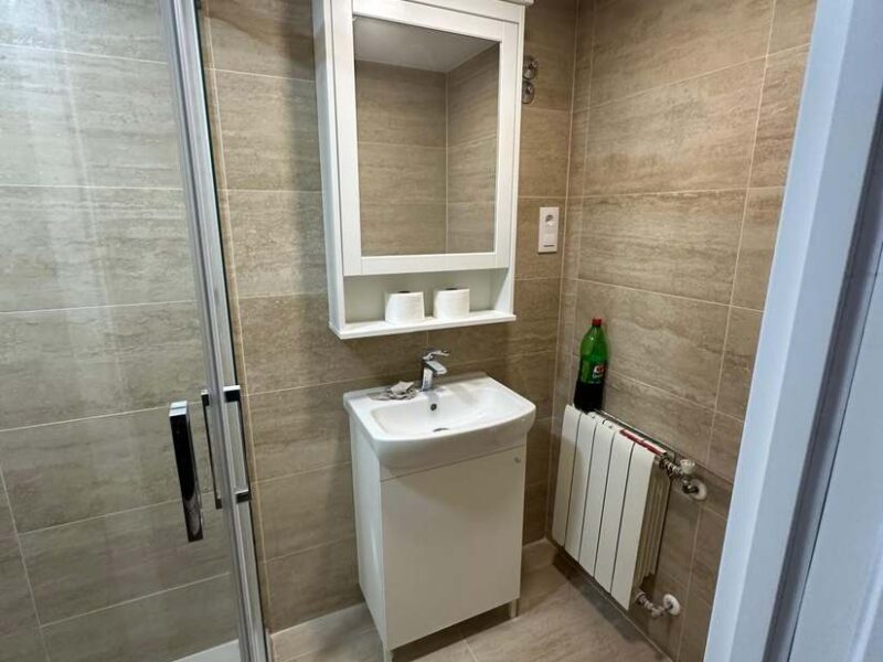 Mueble de lavabo y espejo con luz en baño reformado