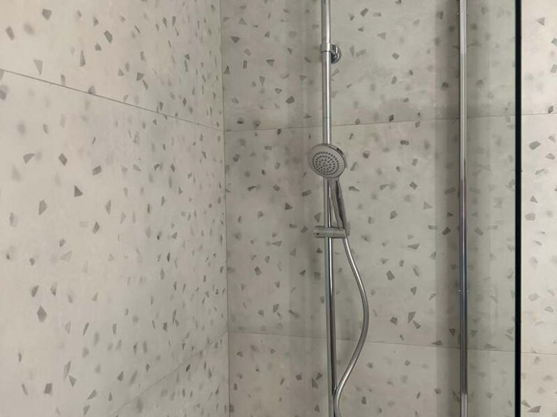 Ducha reformada con alicatado efecto terrazo y columna de hidromasaje