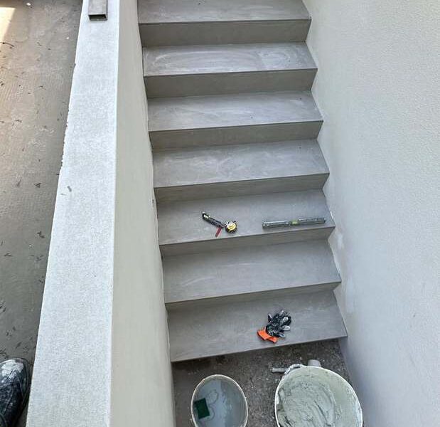 Escalera exterior de obra con peldañeado y muro revestido