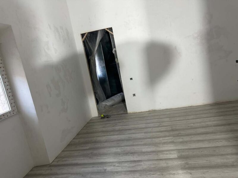 Habitación con suelo laminado y paredes preparadas para pintar