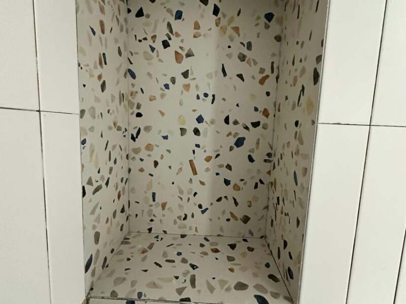 Hornacina de obra en la ducha revestida en efecto terrazo