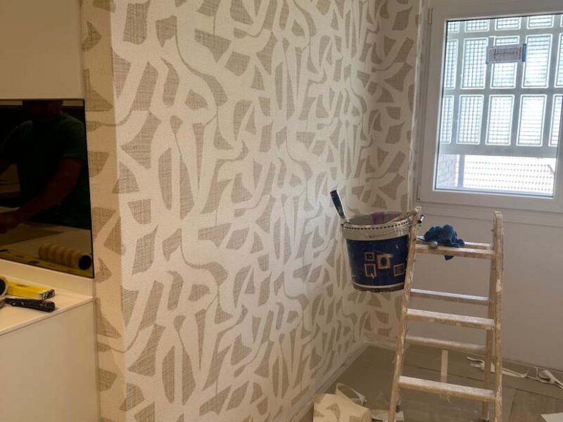 Papel pintado en proceso de colocación sobre pared preparada
