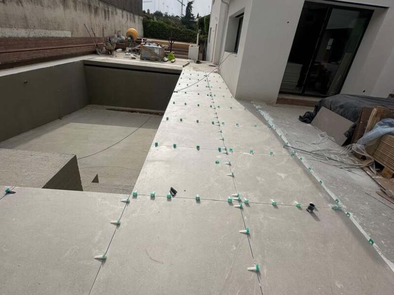 Colocación de porcelánico de gran formato en el perímetro de la piscina