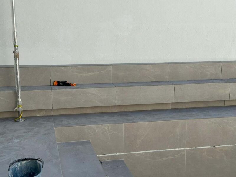 Detalle del banco y la coronación de la piscina en porcelánico