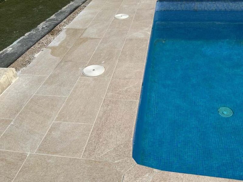 Coronación de piscina en piedra y solado antideslizante perimetral