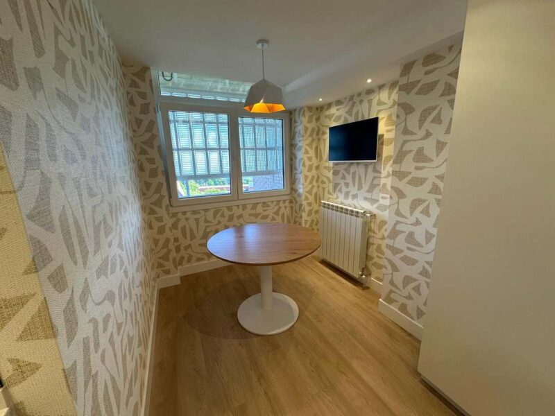 Comedor reformado con papel pintado de diseño y radiador nuevo