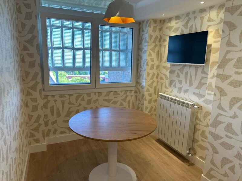 Salón comedor terminado con papel pintado, suelo laminado y luminaria
