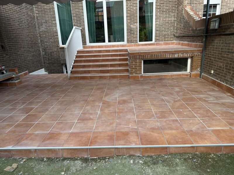 Patio solado en gres rústico con escalera y peldaños de ladrillo