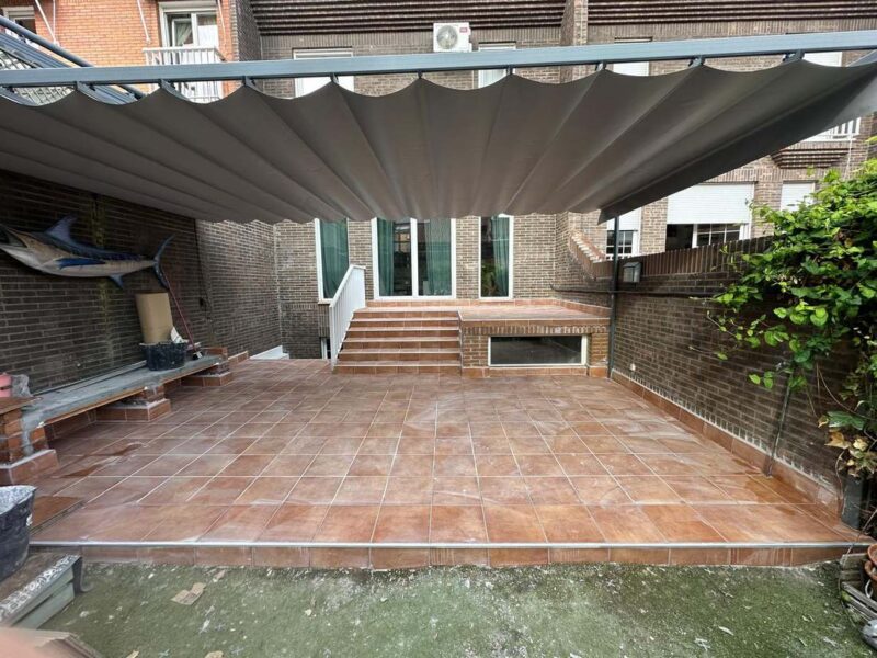 Vista general del patio reformado con pérgola y solado nuevo